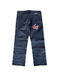 Back view of dark-blue Matty Boy jeans with WHEN pocket graphic and red waistband patch